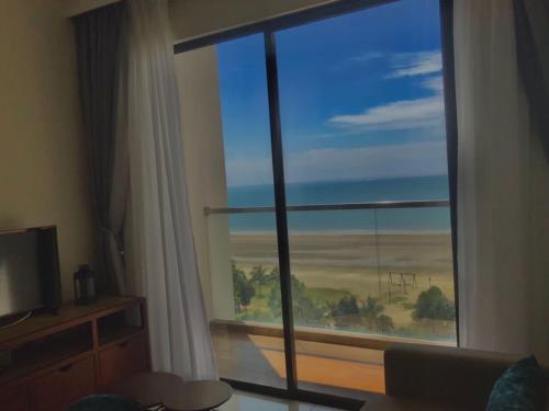 a room with a large window with a view of the ocean at Timurbay by Seascape in Kuantan