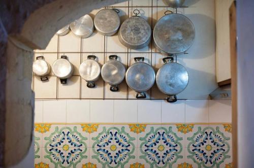a bunch of pots and pans hanging on a wall at Casa nei Fiori di Lecce in Lecce