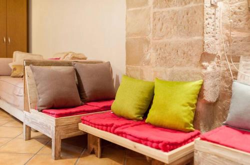 レッチェにあるCasa nei Fiori di Lecceのカラフルな枕付きのソファが備わる客室です。