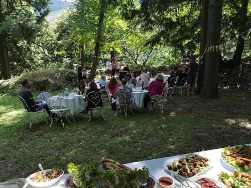 Un groupe de personnes assis à des tables avec des assiettes de nourriture dans l'établissement Logis Hôtel-Restaurant Le Tanargue, à Valgorge