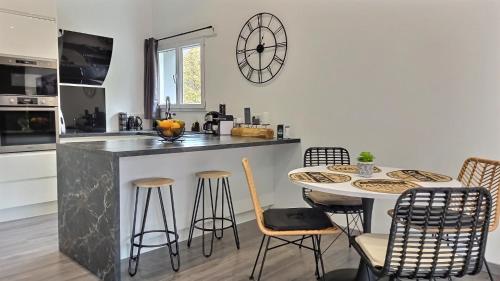 a kitchen with a counter and a table and chairs at Black&White Home-by So'SerenityHome-Balcon-Parking in Cluses