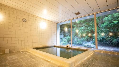 a swimming pool in a room with a large window at Kamogawa Country Hotel in Kamogawa