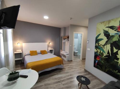 ein Schlafzimmer mit einem Bett und ein Wohnzimmer in der Unterkunft Apartamentos Harmonia in Merida