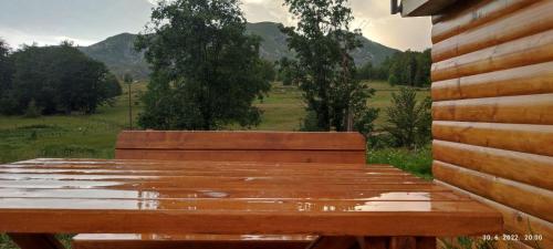 a wooden bench sitting on the side of a house at Mountain inn in Žabljak