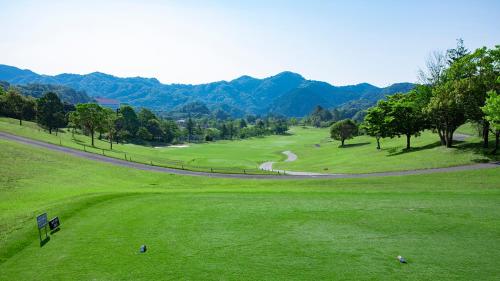 a view of a golf course with mountains in the background at Kamogawa Country Hotel in Kamogawa