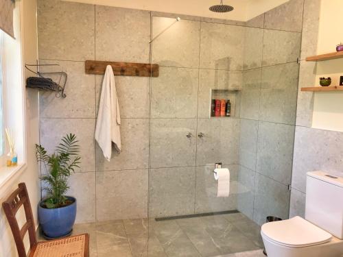 a shower stall in a bathroom with a toilet at Belkampar Retreat - Authentic Farm Style Home - Perfect For Families and Large Groups! in Bonnie Doon
