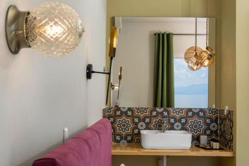 uma sala de estar com um sofá roxo e um espelho em Batelo - Adults Only em Benitses