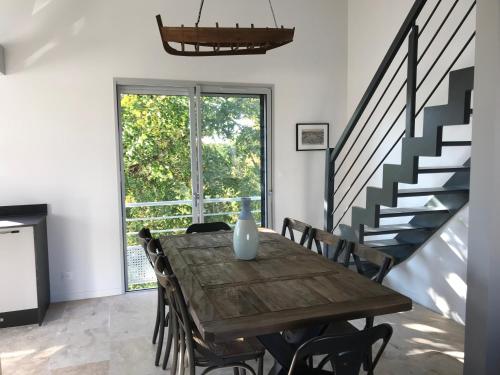 une salle à manger avec une table en bois et des escaliers dans l'établissement Duplex vue sur tour Appartement Remparts 3, à La Rochelle