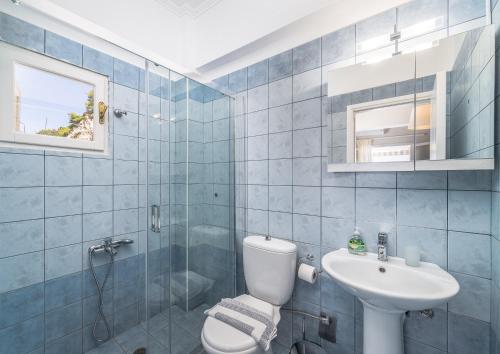 a blue tiled bathroom with a toilet and a sink at Monato Luxury Apartments in Agios Nikitas