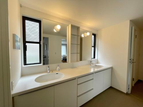 un bagno con due lavandini e un grande specchio di 伊東温泉 Working Base Izu-Ito a Ito