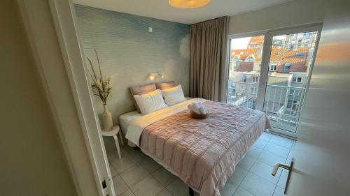 een slaapkamer met een bed en een groot raam bij Zeedijk 264 Knokke-Heist High season saturday to saturday in Knokke-Heist