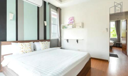 - une chambre avec un grand lit blanc dans l'établissement Villa Rajapruek Entire 3 villa with pool near Airport and city center, à Chiang Mai
