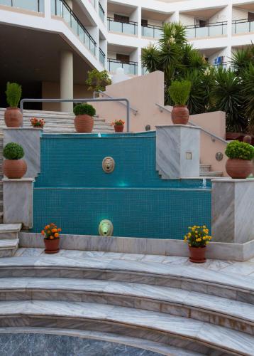 a building with a blue staircase with potted plants at Santa Marina Unique Hotel in Agios Nikolaos