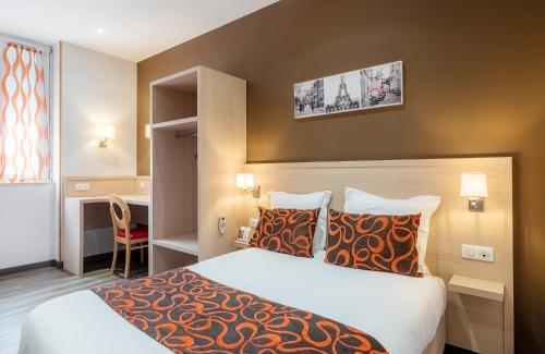 ペリグーにあるThe Originals City, Hôtel Régina, Périgueuxのベッドとデスクが備わるホテルルームです。