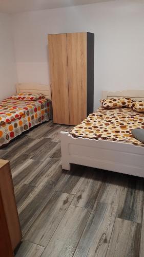 Duas camas num quarto com pisos em madeira em Casa La Bunica em Costinesti