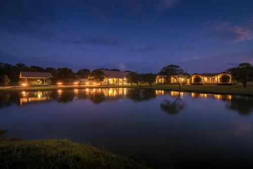 a large lake at night with houses and lights at Kumbukgaha Villa in Sigiriya