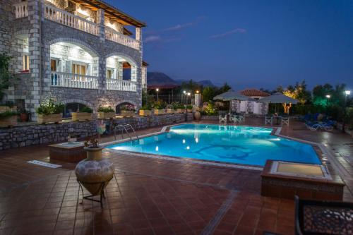a swimming pool in front of a building at Amalia Apartments in Stoupa