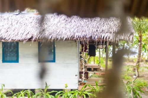 a thatch roofed house with a thatched roof at Tailana Island Pulau Banyak in Alaban