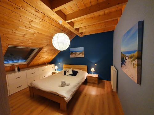 een slaapkamer met een groot bed en een houten plafond bij Gite Li School in Custinne
