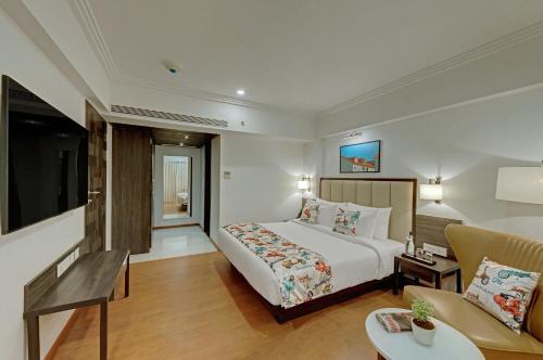 a hotel room with a bed and a couch at The Fern Residency Turbhe in Navi Mumbai