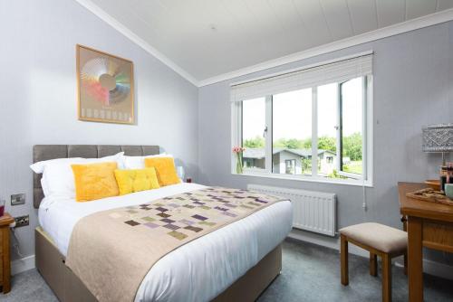 Un pat sau paturi într-o cameră la Clover Lodge, 32 Roadford Lake Lodges, Lifton