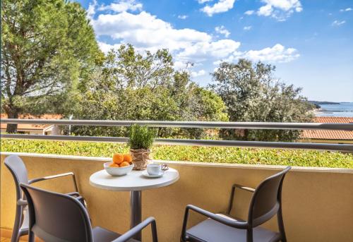 a table and chairs on a balcony with a view of the ocean at Maistra Select Petalon Resort in Vrsar