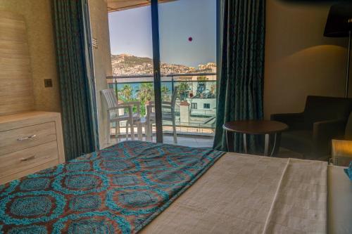 Un dormitorio con una cama y vista a un balcón. en Parador Beach Hotel All Inclusive, en Alanya