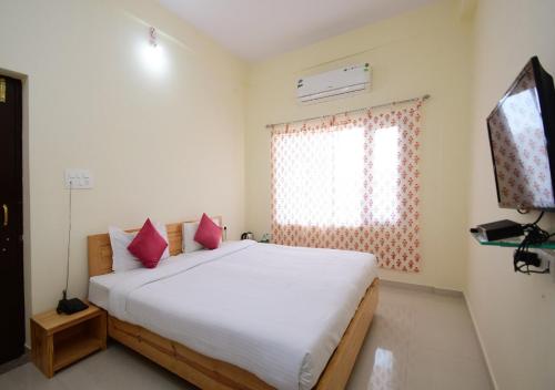 1 dormitorio con 1 cama con almohadas rojas y TV en The Sky Imperial Kumbhalmer Resorts, en Kumbhalgarh