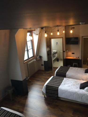een hotelkamer met 2 bedden en een spiegel bij Hôtel - Restaurant Au Tonnelier in Bergues