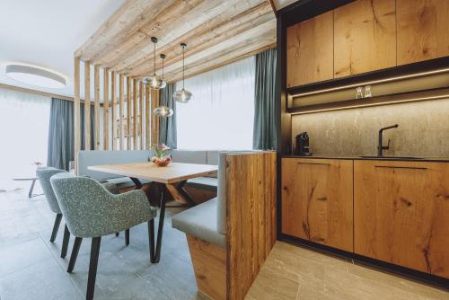 een keuken en eetkamer met een tafel en stoelen bij Bergdorf Hotel Zaglgut in Kaprun