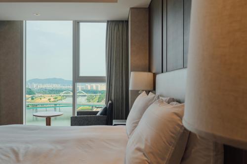 a hotel room with a bed and a large window at LOTTE City Hotel Daejeon in Daejeon