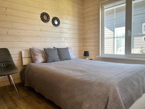 ein Schlafzimmer mit einem Bett und zwei Uhren an der Wand in der Unterkunft Pilkas Namelis - Namelių nuoma Šventojoje in Šventoji