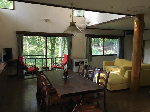 妙高市にあるMyoko Woodland Lodgeのリビングルーム(テーブル、椅子、ソファ付)
