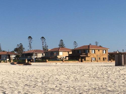a row of houses on the beach near the sand at الساحل الشمالي in Borg El Arab