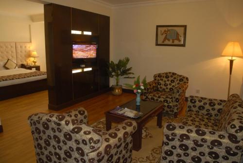a living room with a couch and chairs and a television at Hotel Vaishali in Kathmandu