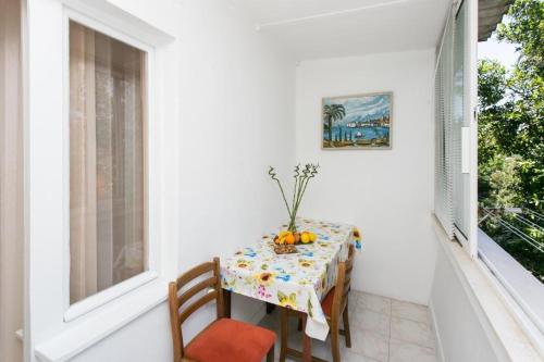a table on a balcony with a table and chairs at Apartment Vukoja in Dubrovnik
