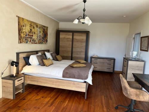 1 dormitorio con 1 cama grande y escritorio en La Fiere Bridge Guest House, en Amfreville