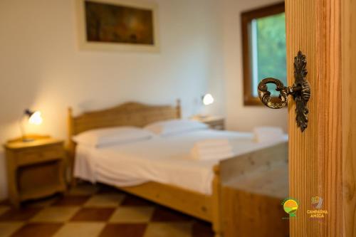a bedroom with a bed with white sheets and a window at La Via Antiga in Cittànova
