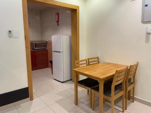 a kitchen with a table and a white refrigerator at أبها ريجنسي in Abha