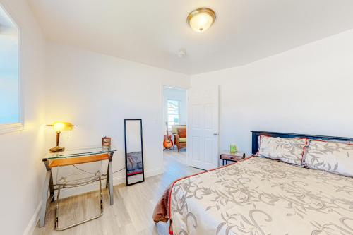 1 dormitorio con cama y escritorio con espejo en Waterfront Escape en Nameloc Heights
