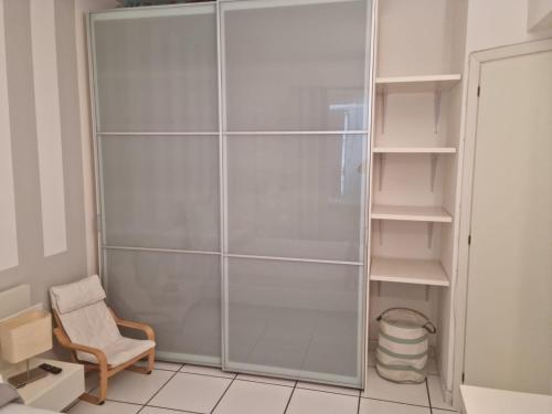 a shower with a glass door and a chair at La Cameretta in Ischia