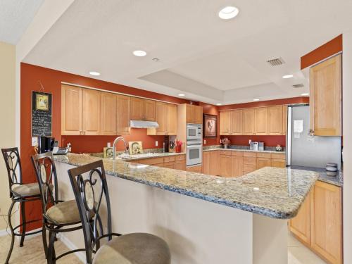 a kitchen with wooden cabinets and a granite counter top at La Vistana 703 in St Pete Beach