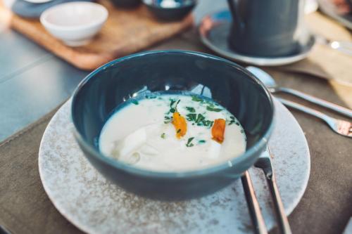 a bowl of soup on a plate on a table at Schlosshotel Brilon-Wald in Brilon-Wald