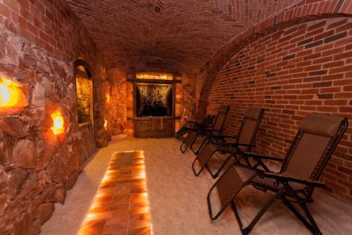 a room with chairs and a brick wall at Pałac Brzeźno Spa & Golf in Oborniki Śląskie