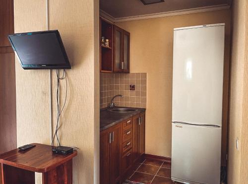 a kitchen with a white refrigerator and a sink at Guest House LETO in Dolinka