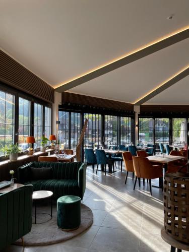 a restaurant with couches and tables and windows at Schlosshotel Brilon-Wald in Brilon-Wald