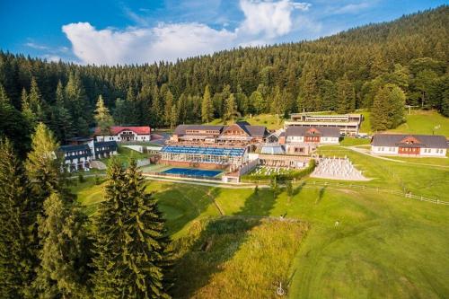 an aerial view of a large house with a golf course at Wellness hotel Horal, Velké Karlovice in Velké Karlovice