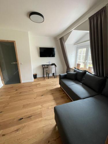 a living room with a couch and a television at Schlosshotel Brilon-Wald in Brilon-Wald