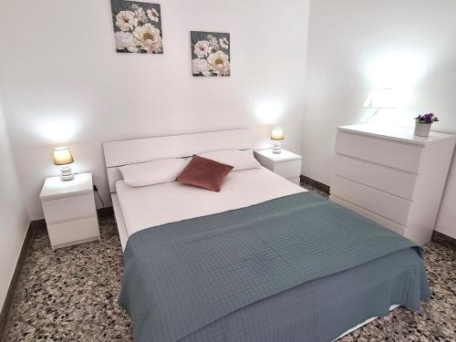 a bedroom with a white bed with two night stands at Casa Lara in Castellammare del Golfo