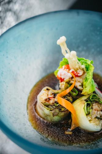 a blue plate of food with vegetables and sauce at Nobu Hotel Warsaw in Warsaw